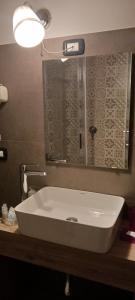 Welcome to I Colori di Napoli في نابولي: حمام مع حوض أبيض ومرآة