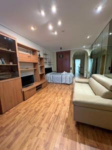 ein Wohnzimmer mit einem Sofa und einem Bett in der Unterkunft Renovado Estudio para parejas con WIFI en la playa in Valencia