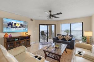 a living room with a couch and a tv at RIVERFRONT VIEW, Stunning Sunrises, Community Pool - Condo Waterfront Sunrise - Roelens in Cape Coral