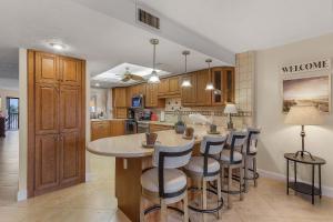 a kitchen with a large island with bar stools at RIVERFRONT VIEW, Stunning Sunrises, Community Pool - Condo Waterfront Sunrise - Roelens in Cape Coral