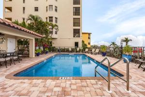 a swimming pool with chairs and a building at RIVERFRONT VIEW, Stunning Sunrises, Community Pool - Condo Waterfront Sunrise - Roelens in Cape Coral