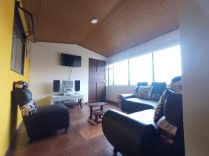 通哈的住宿－Apartamentos Casa MJ Tunja，客厅配有两张沙发和一台电视机