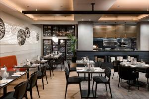 a restaurant with tables and chairs and a kitchen at LUMA Hotel - Times Square in New York