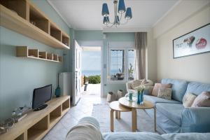 a living room with a blue couch and a table at Pefkohori Blue View by Luxlikehome in Pefkochori
