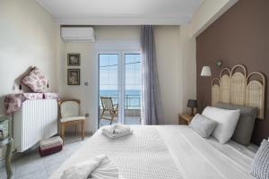 a bedroom with a large bed with a view of the ocean at Pefkohori Blue View by Luxlikehome in Pefkochori