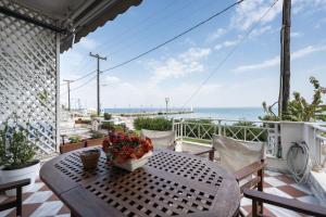 a table on a balcony with a view of the ocean at Pefkohori Blue View by Luxlikehome in Pefkochori