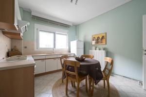 a kitchen with a table and chairs in a room at Pefkohori Blue View by Luxlikehome in Pefkochori
