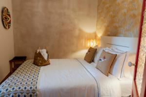 een slaapkamer met een groot wit bed met kussens bij Portas da Cidade Home in Silves