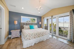 a bedroom with a bed with blue walls and a window at Southern Exposure AMV in Anna Maria +54 photos
