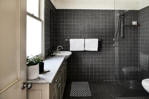 a bathroom with a shower and a sink and a toilet at The Tailor's Cottage Kangaroo Valley in Kangaroo Valley +17 photos