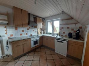 a kitchen with wooden cabinets and white appliances at Ferienwohnung Oflings in Wangen im Allgäu