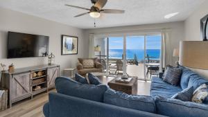 a living room with a blue couch and a tv at Blue Nine 5 in Panama City Beach