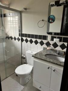 a bathroom with a toilet and a sink and a shower at Casa de Praia Riviera de Sao Lourenco - Vilagio in Bertioga