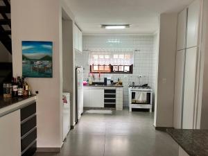 a white kitchen with a refrigerator and a stove at Casa de Praia Riviera de Sao Lourenco - Vilagio in Bertioga