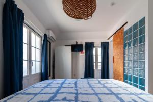 a bedroom with a blue and white bed with blue curtains at NewStar Duplex in Setúbal