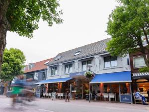 a man riding a bike down a street next to a building at Hotel de Burg in Domburg