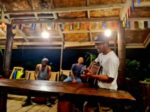 a group of men standing around a wooden table at Batu Kapal Guest House & Jungle trekking in Bukit Lawang +93 photos