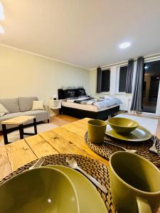 a living room with a table with bowls on it at Studio an der Elbe mit Balkon, Küche und Netflix in Dresden
