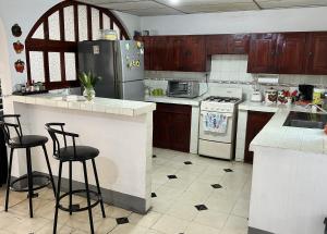 La cuisine est équipée d'un réfrigérateur et de deux tabourets de bar. dans l'établissement El Callejon Guest House, à León