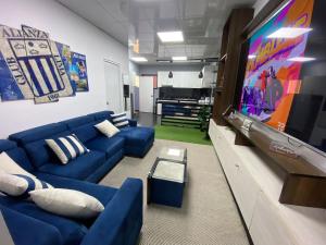 a living room with a blue couch and a flat screen tv at REBER CERCA DEL AERO PUERTO in Lima