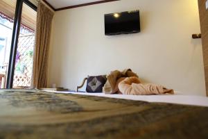 a bedroom with a bed with a television on the wall at Tanee Place in Bangkok