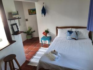 a bedroom with a bed with a teddy bear on it at Chalé Flor do Ser in Canoa Quebrada