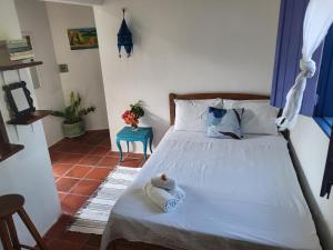 a bedroom with a bed with a teddy bear on it at Chalé Flor do Ser in Canoa Quebrada