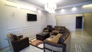sala de estar con sofás y TV de pantalla plana. en Malaz Qaroun - ملاذ قارون en Qaryat at Ta‘mīr as Siyāḩīyah