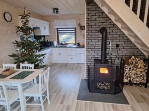 a kitchen with a fireplace and a christmas tree at Domek Leniuchowo in Rabka-Zdrój