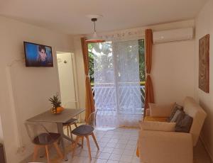 a living room with a couch and a table at Studio Beachside Paradise avec citerne tampon- Résidence Manganao in Saint-François