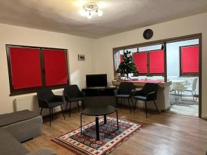 sala de estar con mesa, sillas y mesa con ordenador portátil en Casa Demény, en Sovata