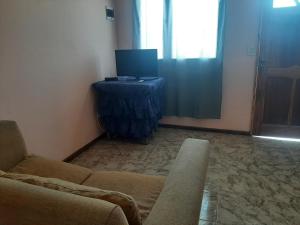 a living room with a couch and a television at La Casa de Zoe in Perito Moreno