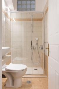 a bathroom with a shower with a toilet and a sink at Virginia's Luxury Suites 2 in Volos