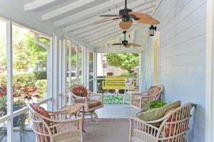 a porch with wicker chairs and a ceiling fan at The Gathering Place in Bradenton