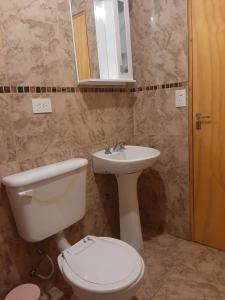 a bathroom with a toilet and a sink at La Casa de Zoe in Perito Moreno