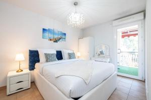 1 dormitorio con cama blanca y lámpara de araña en Intercontinental Superbe appartement avec piscine en Menton