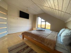 1 dormitorio con 1 cama en una habitación con ventana en Маєток на Озерах en Ispas
