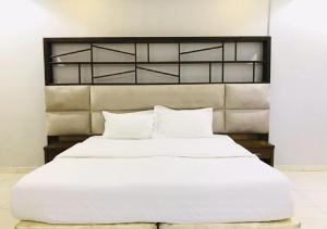 a large white bed with white pillows in a bedroom at الحمدانية الراقي للأجنحة الفندقية in Jeddah