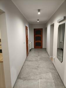 a hallway with a door and a tile floor at Noclegi w Dolinie Drwęcy in Kurzętnik
