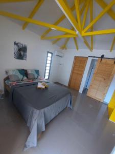 een slaapkamer met een groot bed en 2 houten deuren bij L’envolée bleue in Saint-Louis