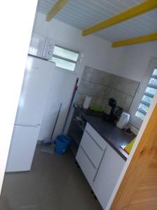 een keuken met een witte koelkast en een wastafel bij L’envolée bleue in Saint-Louis