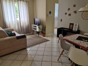 a living room with a couch and a tv at Apartamento Vila do Sol in Blumenau