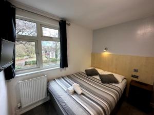 a bedroom with a bed and a large window at Gainsborough Lodge in Horley
