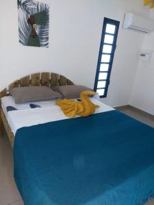 een slaapkamer met een bed met een handdoek erop bij L’envolée bleue in Saint-Louis