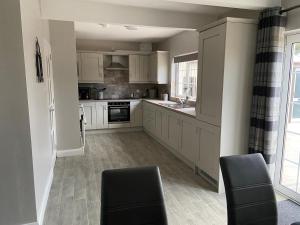 a kitchen with white cabinets and a sink at Drumnieve Lodge in Kesh