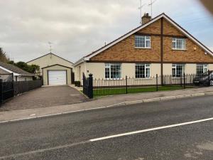 a house with a fence on the side of a street at Drumnieve Lodge in Kesh