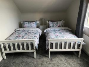two beds in a small room with two bedsitures at Drumnieve Lodge in Kesh