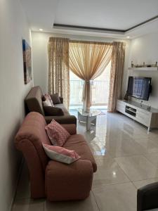 - un salon avec deux canapés et une télévision dans l'établissement Orchidea Appartment, à Għajnsielem