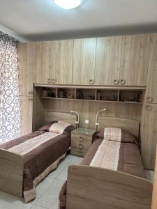 2 Betten in einem Zimmer mit Holzschränken in der Unterkunft Orchidea Appartment in Għajnsielem