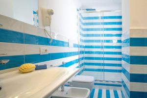 a blue and white bathroom with a tub and a toilet at SorrentoVibes - Deluxe Apartment in Sorrento Centre in Sorrento